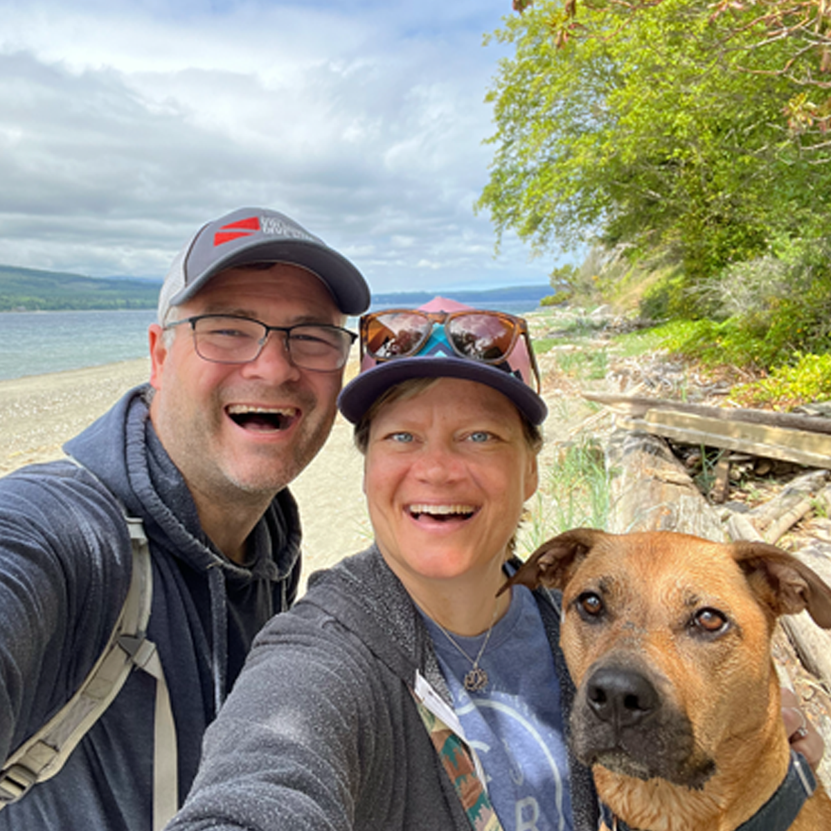 Mike, Christa, and Rikka smiling for a cheerful selfie during a family walk on the beach in Port Townsend.